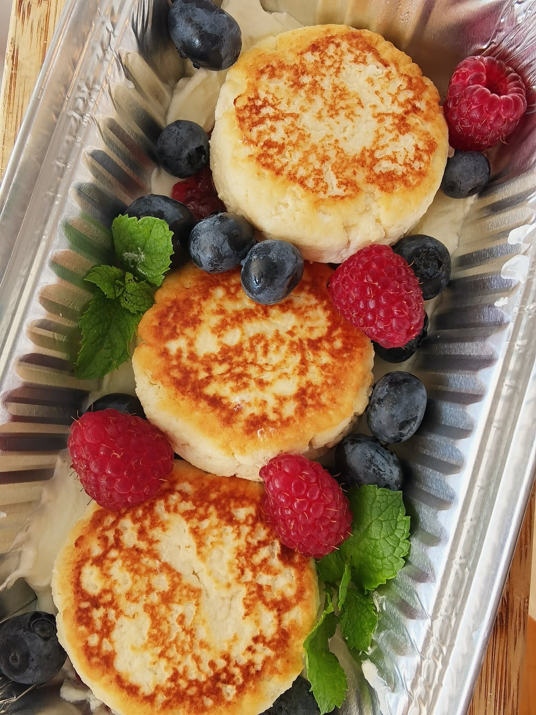 Syrniki (cottage cheese pancakes) served with fresh berries