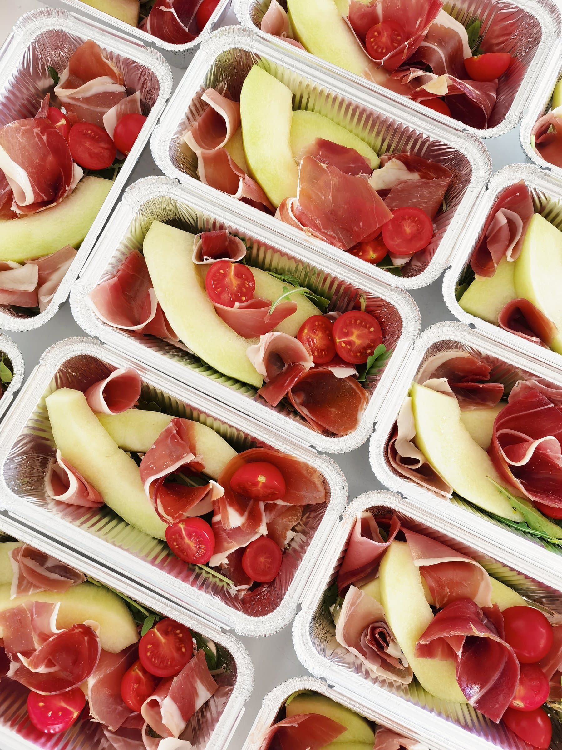 Prosciutto e melone: thin slices of prosciutto with cantaloupe melon, cherry tomatoes, and arugula, a classic Italian antipasto
