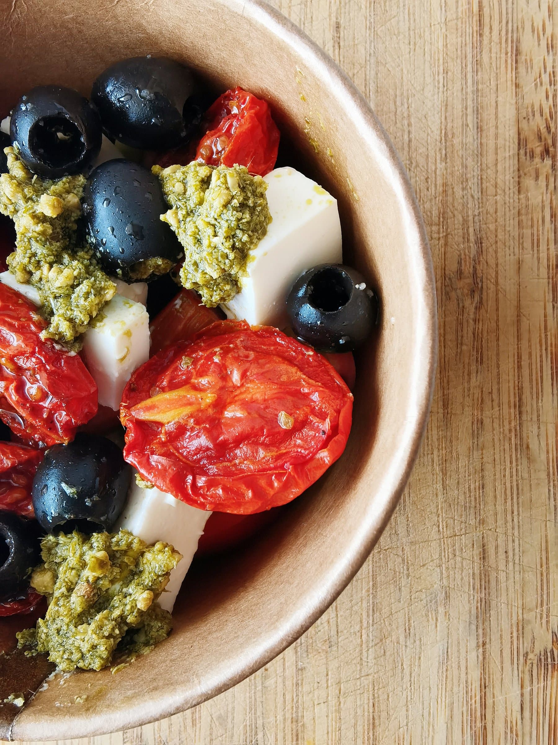 Signature Greek salad with feta, olives, and blistered cherry tomatoes with pesto